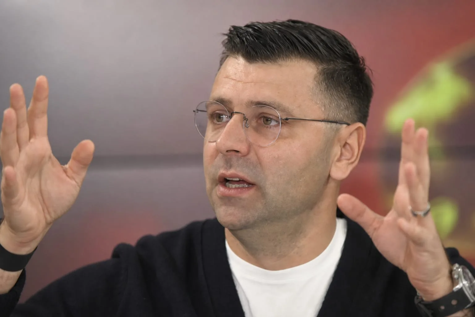Bărbat cu ochelari și cardigan negru